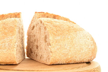 Two halves of a delicious loaf without yeast with bran cereal on a round wooden tray, close-up, isolated on white.