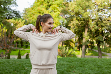 Young smiling fit woman warming up before training outdoors. Healthy lifestyle