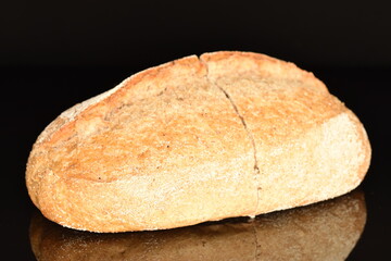 One loaf without yeast with bran cereal, close-up, on a black background.