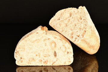 Two halves of a delicious loaf without yeast with bran cereal, close-up, isolated on black.