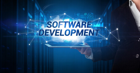 Young business person working on tablet and shows the inscription: SOFTWARE DEVELOPMENT
