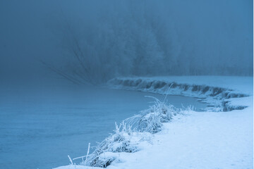 High sandy shores of the lake covered with snow