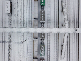 Snow-covered bridge over the railway. Snowy day, blizzard. Aerial drone view.