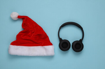 Santa hat and Headphones on blue background. Christmas party. Top view. Flat lay