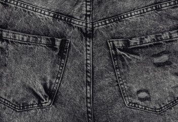 Back pockets of gray jeans close up