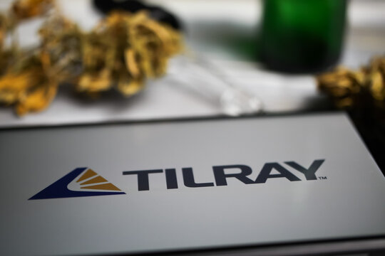 Viersen, Germany - January 9. 2021: Closeup of mobile phone screen with logo lettering of cannabinoid company Tilray, blurred marijuana and pipette background
