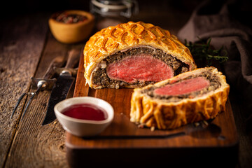 Perfect homemade juicy Beef Wellington, tenderloin dish on rustic wooden table