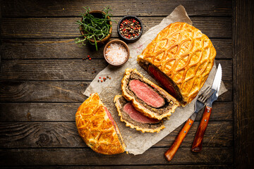 Perfect homemade juicy Beef Wellington, tenderloin dish on rustic wooden table, top view