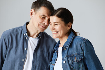 Studio shot of beautiful senior couple posing against a grey background  in casual clothes isolated over grey background