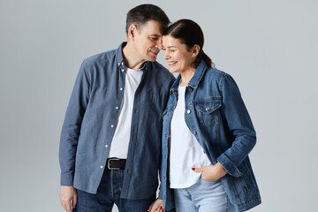 Studio shot of beautiful senior couple posing against a grey background  in casual clothes isolated over grey background