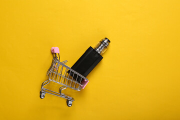 Shopping trolley with vaping device (electronic hookah or cigarette) on yellow background. Top view