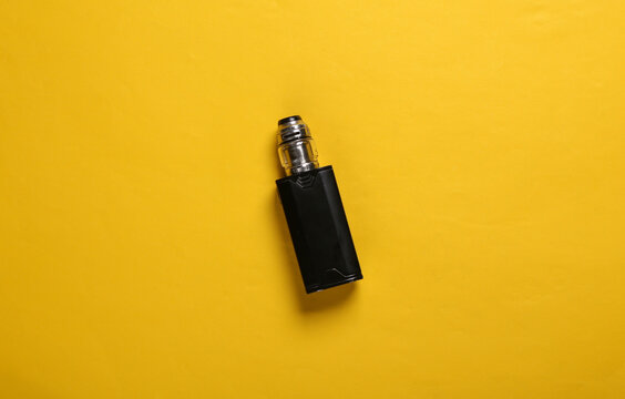 Vaping device (electronic hookah or cigarette) on a yellow background. Top view
