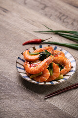 Delicious pan-fried shrimp on dark wooden table background.