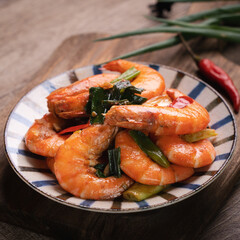 Delicious pan-fried shrimp on dark wooden table background.