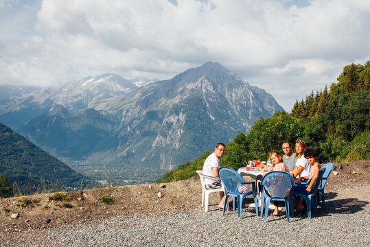 une famille d&eacute;jeunant face &agrave; un panorama. Un pique-nique devant les Alpes. Des amis mangeant &agrave; l'ext&eacute;rieur. La vie en pleine air