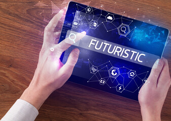Close-up of a tablet searching FUTURISTIC inscription, hi-tech computing concept