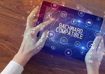 Close-up of a tablet with BACKWARD COMPATIBLE inscription, innovative technology concept