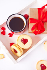Heart shaped traditional linzer cookies with strawberry jam, mug of coffee and gift box. Valentine s day concept.