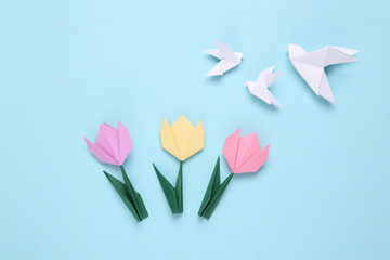 Handmade origami paper tulips and pigeons.on blue background. 8 March, mother's day or easter concept. Top view. Minimalism