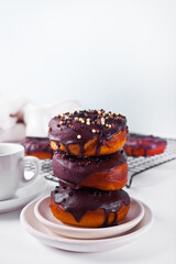Doughnut glazed with chocolate cream or icing and cup of coffee. Breakfast concept.