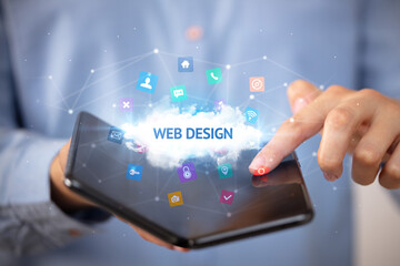 Businessman holding a foldable smartphone with WEB DESIGN inscription, technology concept