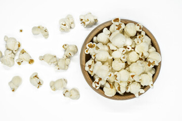 pop corn in wooden bowl with spoon isolated on a white background