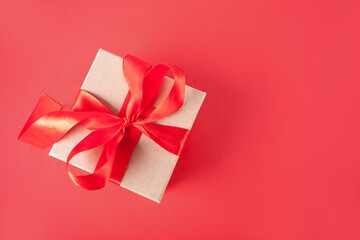 Valentines day greeting card with gift box on red background. Copy space for greetings.
