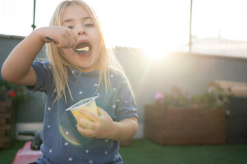 Niña rubia comiéndose un flan