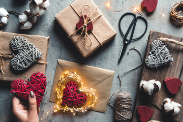 holidays, people and celebration concept - close up of woman decorating valentine present