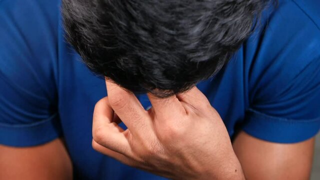 Young man suffering headache looking down 