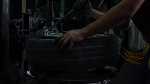 mechanic applying grease for remove old damaged and worn out of car tire tread by tire removal machinery equipment repairing . engineer repair rubber from wheel disc in workshop at car  service garage