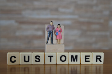 Selective focus of miniature peoples and scrabble letters with text CUSTOMER. Business concept. 