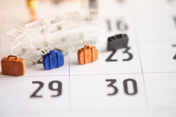 Miniature Tourists standing on the calendar with bags