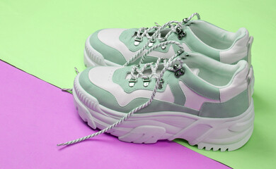 Fashionable sneakers with high soles (platform) on pink green background. Minimalism