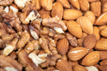 Almonds and walnuts scattered on the table. Close-up, selective focus.