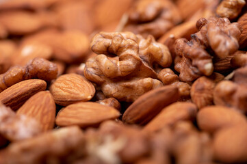 Almonds and walnuts scattered on the table. Close-up, selective focus.
