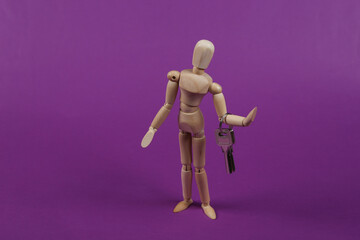 Wooden puppet holds bunch of keys on a purple background.