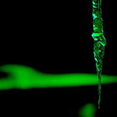 dynamic image showing an icicle with a green glow. suquare croped