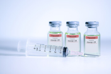 Coronavirus COVID-19 concept. liquid in vaccine vials and Syringe on white background and Selective focus