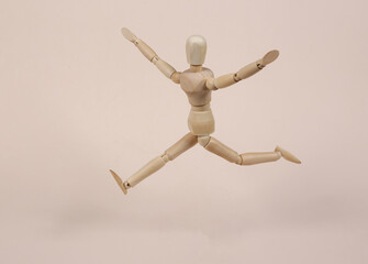 Happy wooden puppet on a beige background. Positive emotions