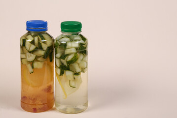 Detox drink, cucumber lemonade bottles on beige background