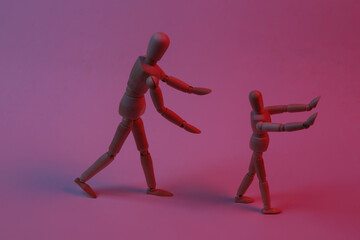 Two puppets impersonating a guardian and a child fooling around in red neon light. Spending time...