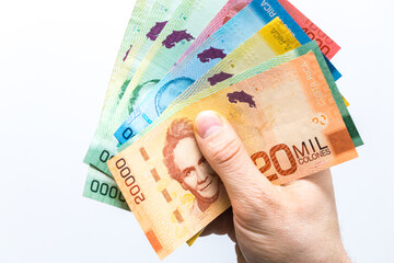 Costa Rican money, Colones, Banknotes spread out in a fan and held in a male hand, White background