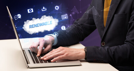 Businessman working on laptop with RENEWABLE inscription, modern technology concept