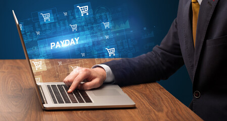 Businessman working on laptop with PAYDAY inscription, online shopping concept