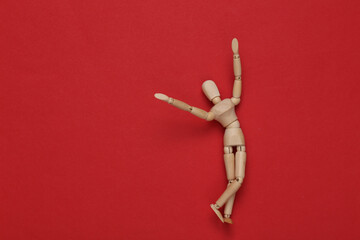 Wooden puppet mannequin shows empty space for your text on red background. Copy space