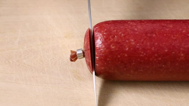 Slicing  beef salami sausage close up