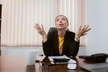 Puzzled business lady boss in her office sitting at the table