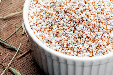 Amaranth in white bowl isolated on wooden background
