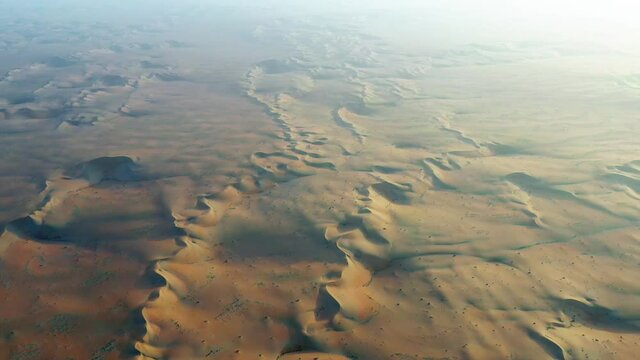 Aerial view over patterns on sand dunes, sunset at a desert - tracking, drone shot